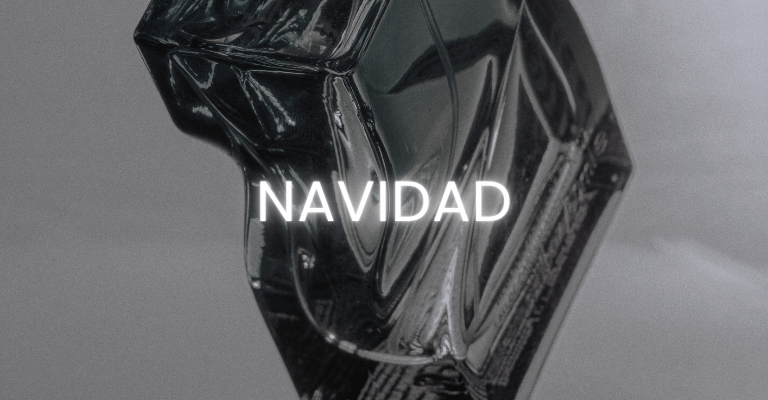 Texto el brillo de la navidad junto a frascos de perfume dorados